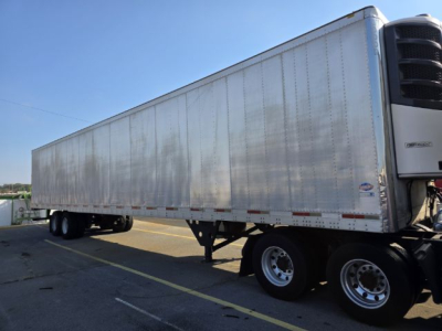 Trailer showing a long aluminum box with tandem axles and a refrigeration unit at the front, 2005 Utility 3000R reefer trailer.