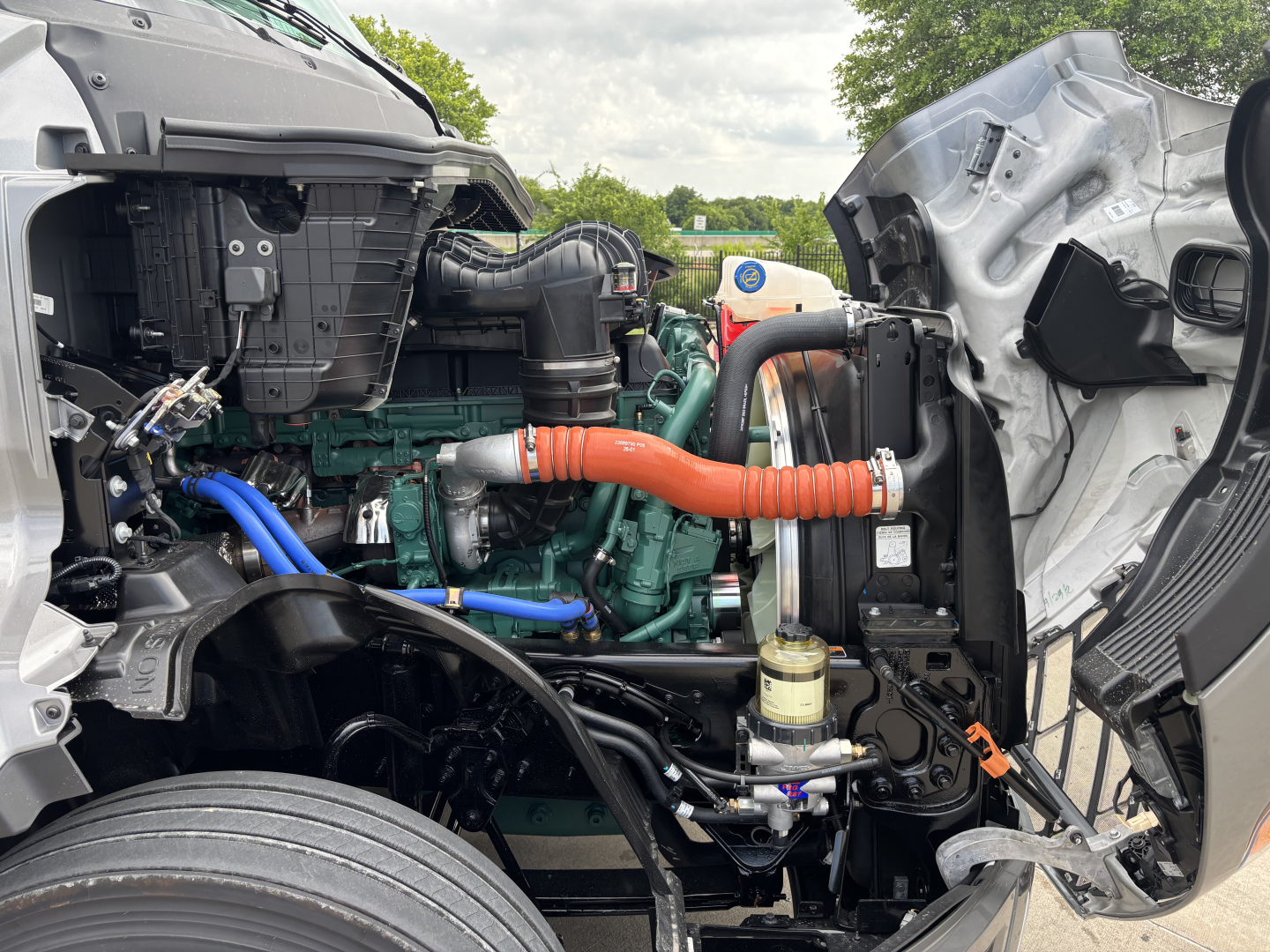 Volvo VNL64T860 engine bay showing coolant hoses, turbo, and various components.