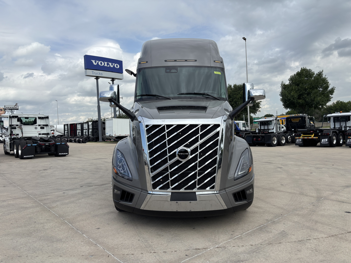 Volvo VNL64T860 truck front view in a dealership lot showing chrome grille and Volvo badge.