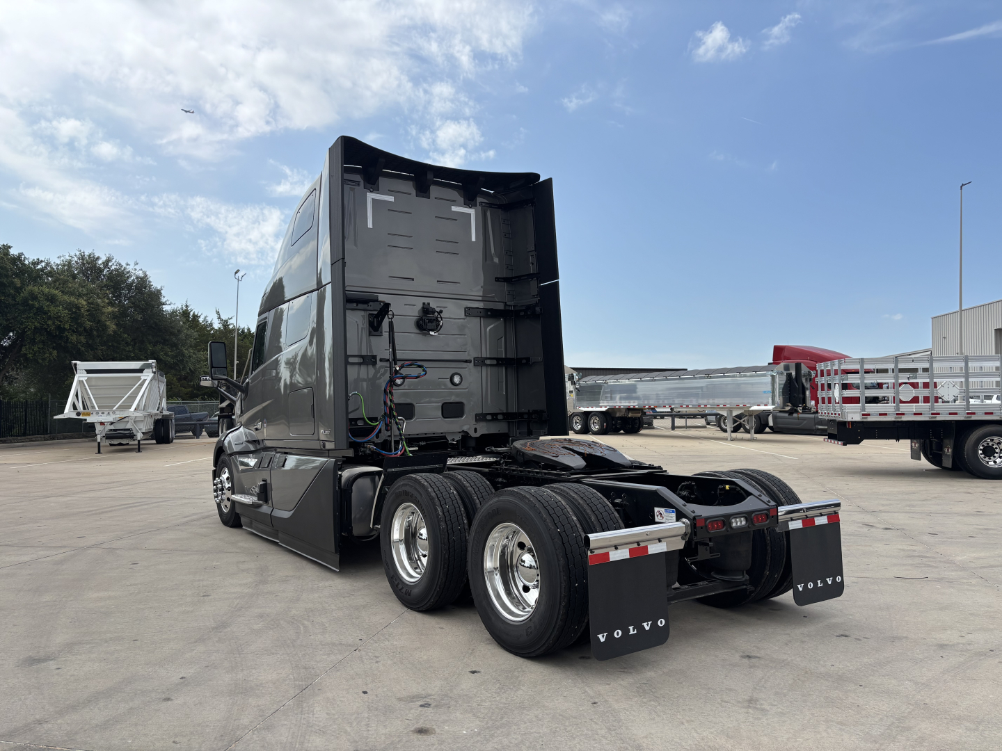 Volvo VNL64T860 tractor cab, rear view showing twin axles, fifth wheel and chassis, with exposed wiring and open rear cabin area.