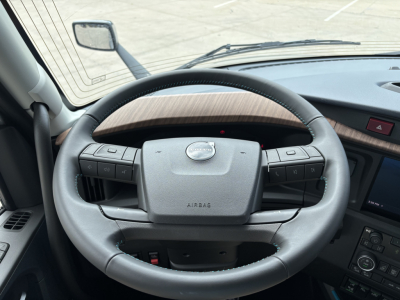 Steering wheel and dashboard view inside a Volvo truck cab. Visible text includes ‘AIRBAG’ on the center of the steering wheel. No other legible text.