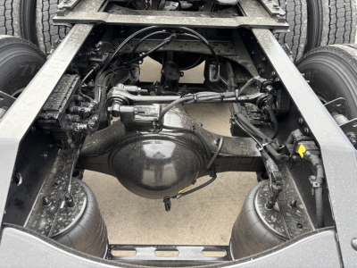 Volvo VNL chassis rear view showing driveline differential, suspension, and dual rear axles with wiring harnesses and frame rails.