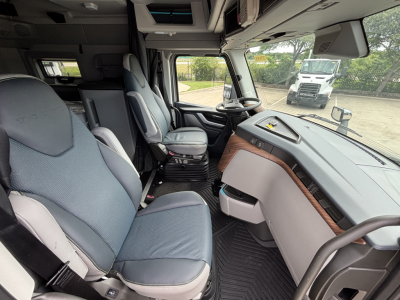 Truck cab interior of a 2027 Volvo VNL64T860 showing steering wheel, dashboard, and seating.