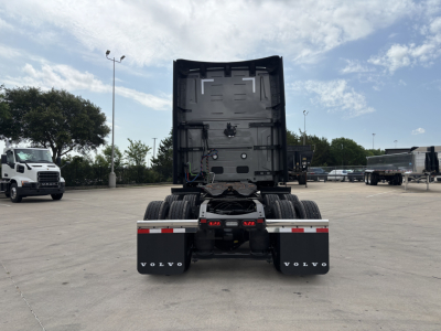 Volvo VNL64T860 tractor rear view showing fifth wheel and dual rear axles with mud flaps and Volvo branding.