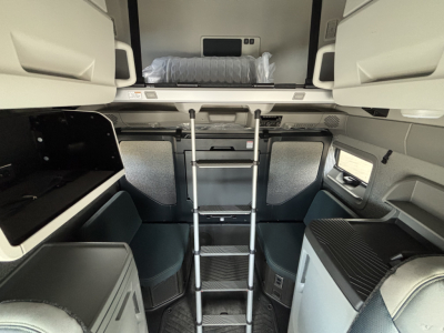 Volvo VNL64T860 sleeper cab interior showing overhead bunk ladder and front seating area.