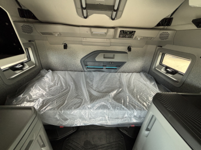 Volvo VNL64T860 sleeper cab interior with plastic-covered bunk area and overhead controls.
