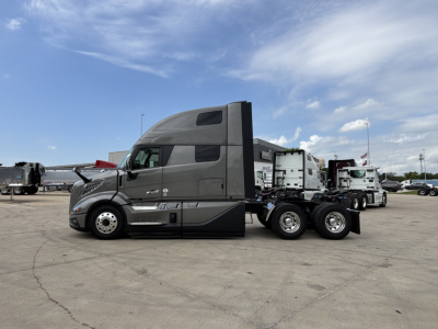 Volvo VNL64T860 truck tractor side view showing sleeper cab and rear axles with fifth wheel.