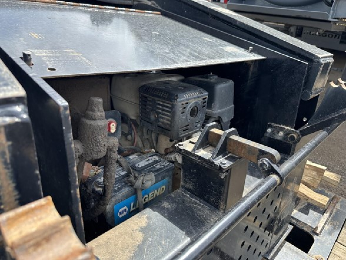 Load King Mech Stinger trailer engine bay showing GM Legend battery and small diesel/ID engine with air intake and wiring.