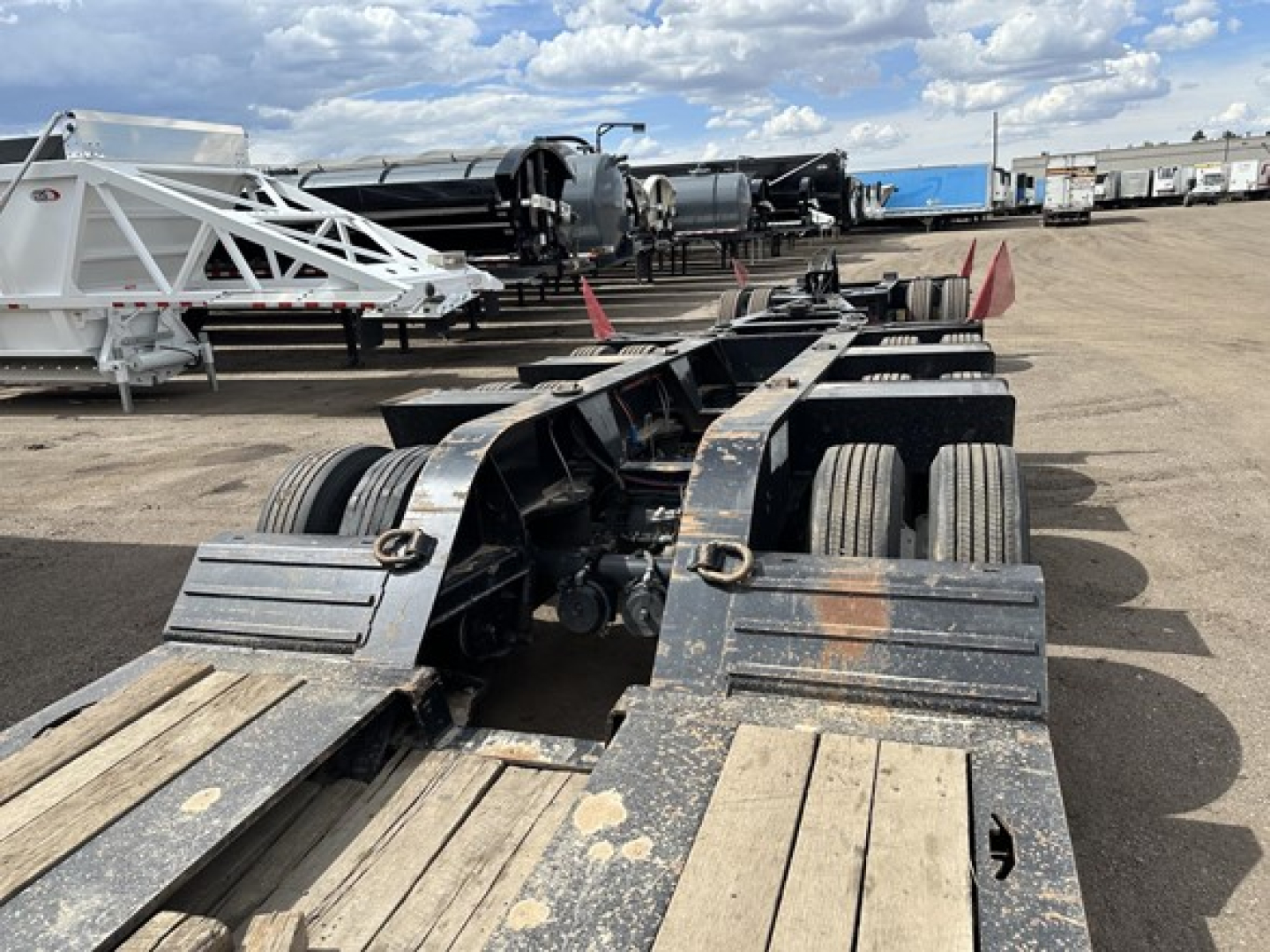 Load King Mech Stinger lowboy trailer chassis with multiple axles and wooden deck sections.