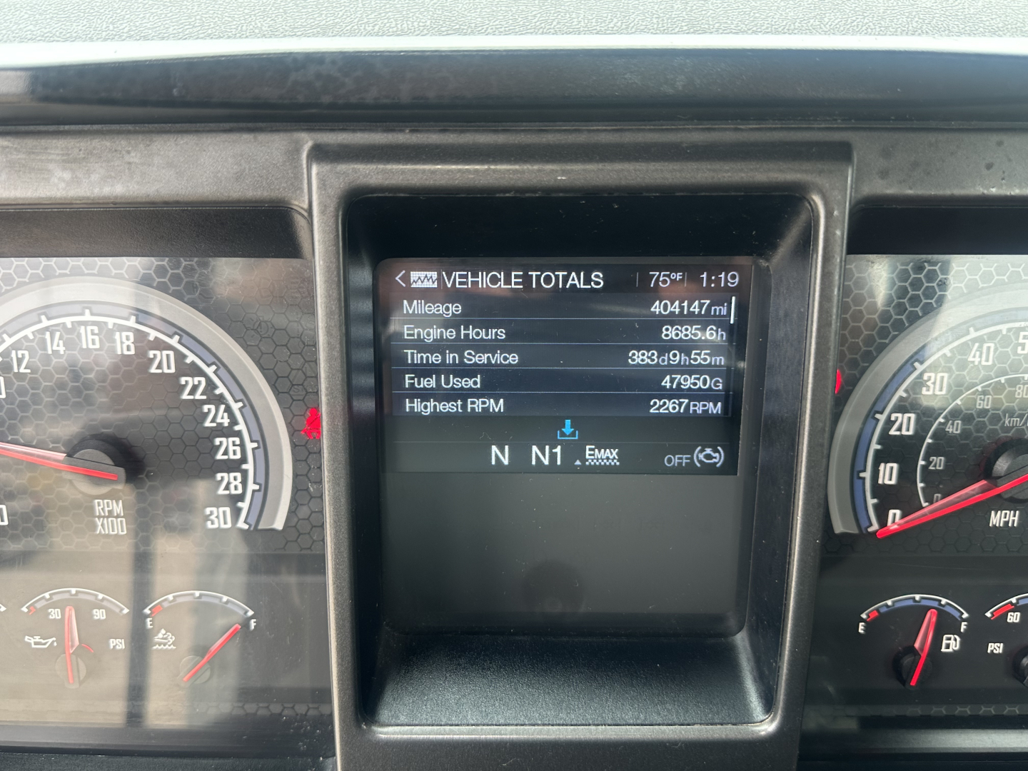 Dashboard display showing vehicle totals and digital readout on a Mack AN42T cab; gauges visible on left and right.