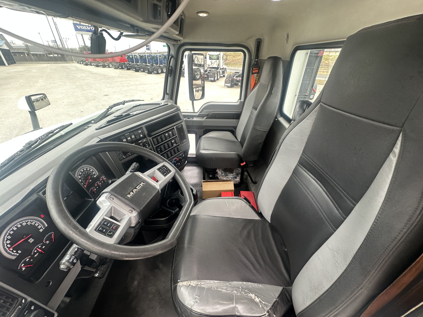 Mack AN42T truck interior showing steering wheel, dash gauges, driver seat, and passenger seat in cab view.