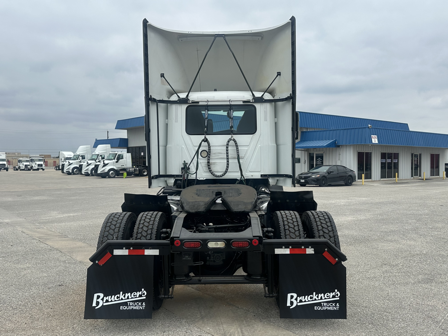Rear view of a white 2022 Mack AN42T daycab truck chassis showing fifth wheel, rear lights, and mud flaps with Bruckner's branding.