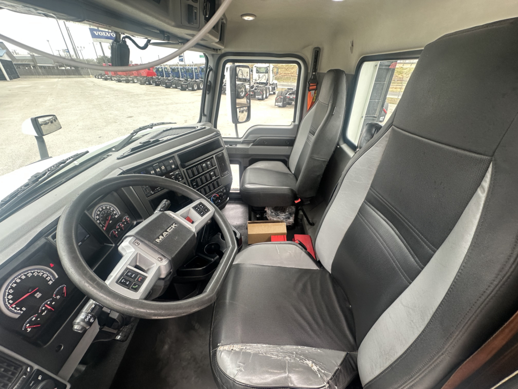 Mack AN42T truck interior showing steering wheel, dash gauges, driver seat, and passenger seat in cab view.