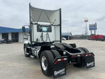 Truck chassis rear view showing fifth wheel, dual fuel tanks, rear mud flaps, and wheel axles of a 2022 Mack AN42T conventional daycab used truck.