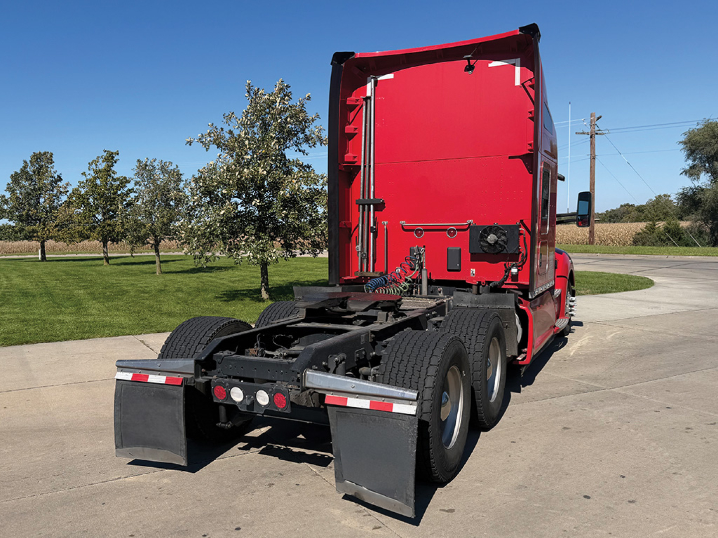 Kenworth T680 rear view showing fifth wheel cradle, dual rear axles, and red sleeper cab