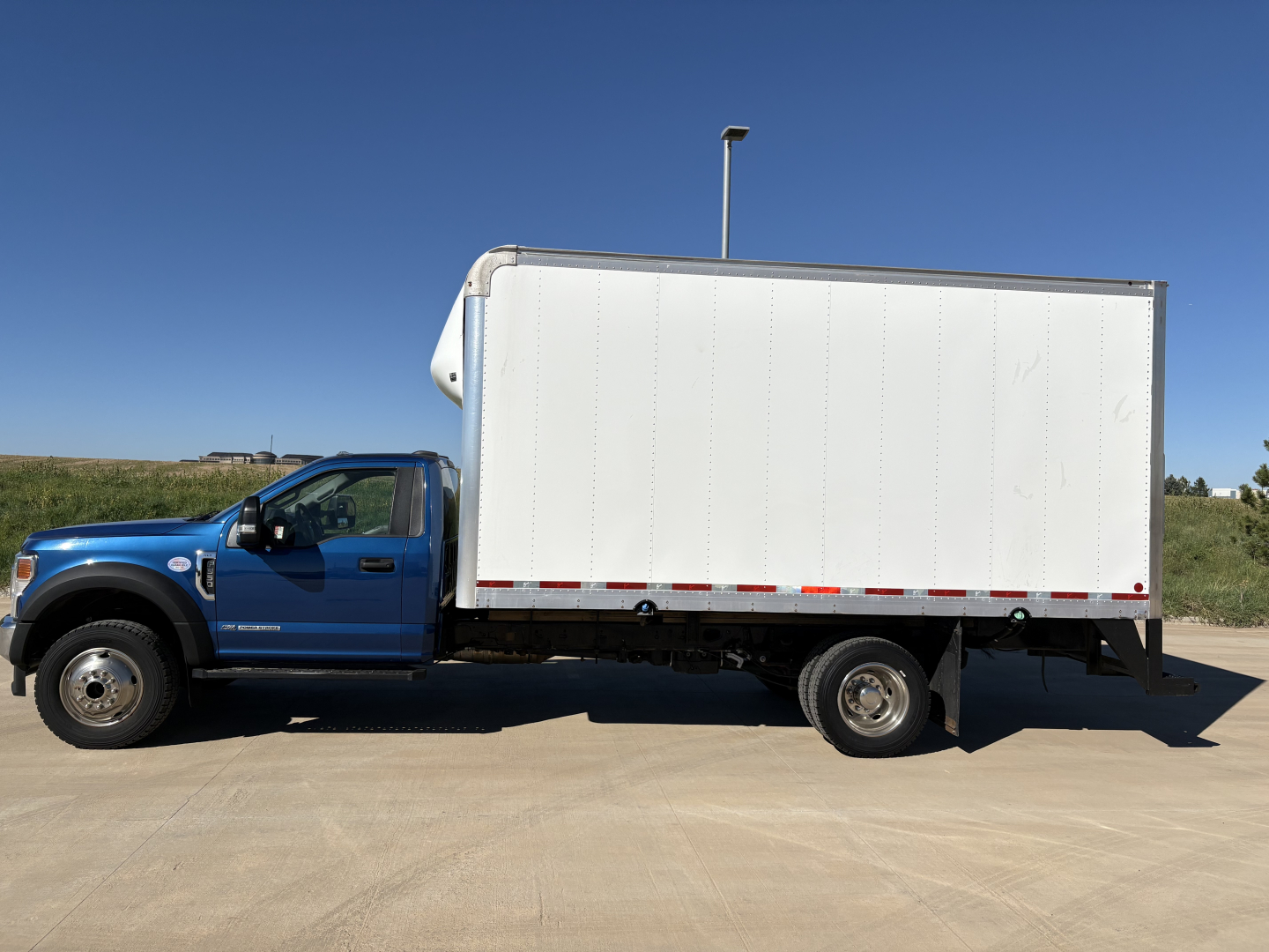 Ford F-550 box truck side view showing cargo box and cab with blue color.