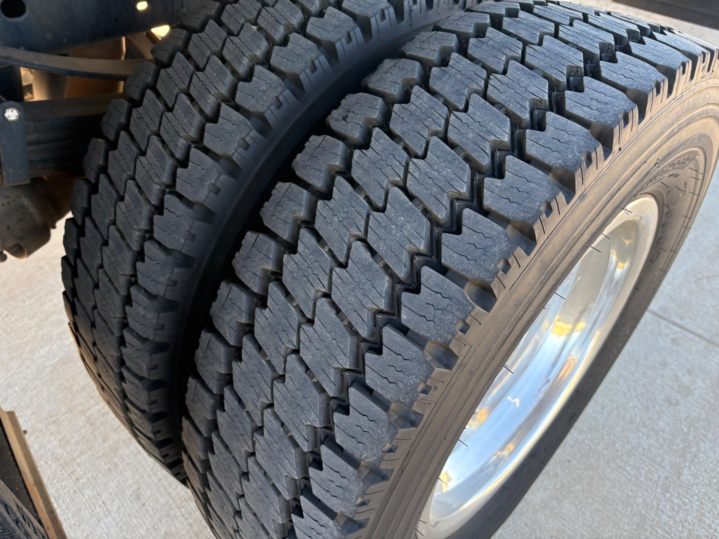Ford F-550 wheel and tire close-up showing heavy tread pattern and chrome wheel.
