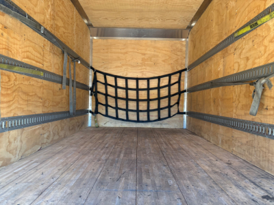 Box truck cargo area with wooden floor and side walls, black cargo net at back, metal E-track rails along walls, tie-down hooks, empty interior.