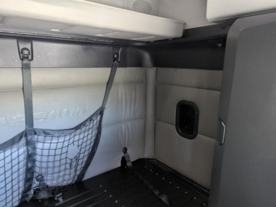 Freightliner Cascadia cab interior showing sleeper area with mesh storage net and side wall panel.