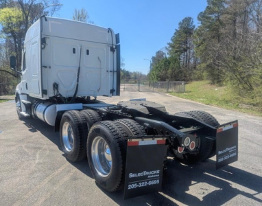 Freightliner Cascadia 126 tractor rear view showing tandem axle setup, black chassis, silver cab, rear mud flaps with SelectTrucks branding and contact numbers.