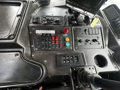 Dashboard/control panel of 2019 Autocar XPEDITOR showing switches, gauges, and monitor with labeled buttons and dials.