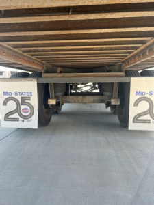 Rear view of a 2014 utility van undercarriage showing suspension and wheels, with mud flaps labeled 'Mid-States 25' and visible VIN/stock details in listing.