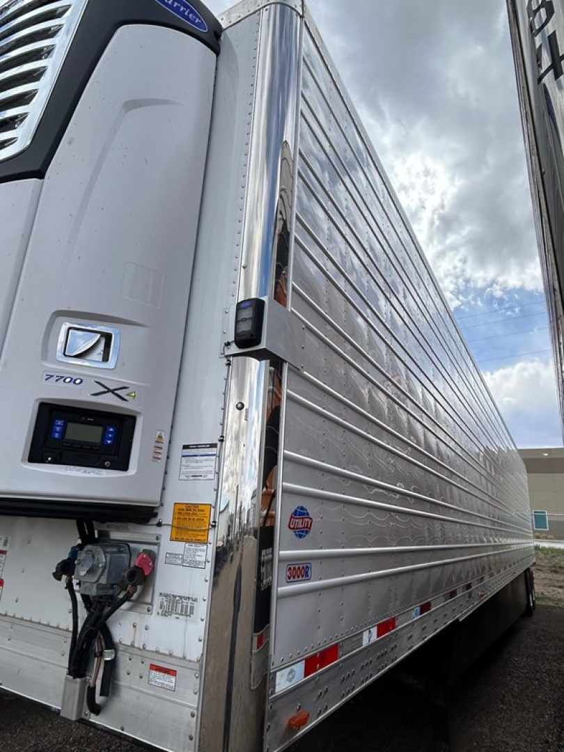 Utility 3000R trailer side and front showing Y8000-X refrigeration unit, latching doors, aluminum side panels, and safety decals.