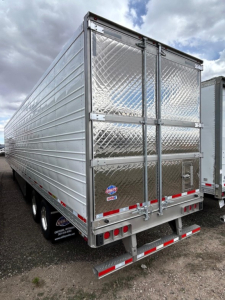 Trailer rear view of a new 2026 Utility 3000R reefer trailer with diamond plate rear doors and triple axle dual-tandem, side vents, and bumper with reflective tape.