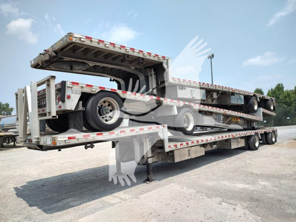 Trailer deck system showing a 2018 Reitnouer Dropmiser drop deck trailer with extended flatbed and wheel chocks, stock number 48-6140, VIN 1RND48A26JR044986.