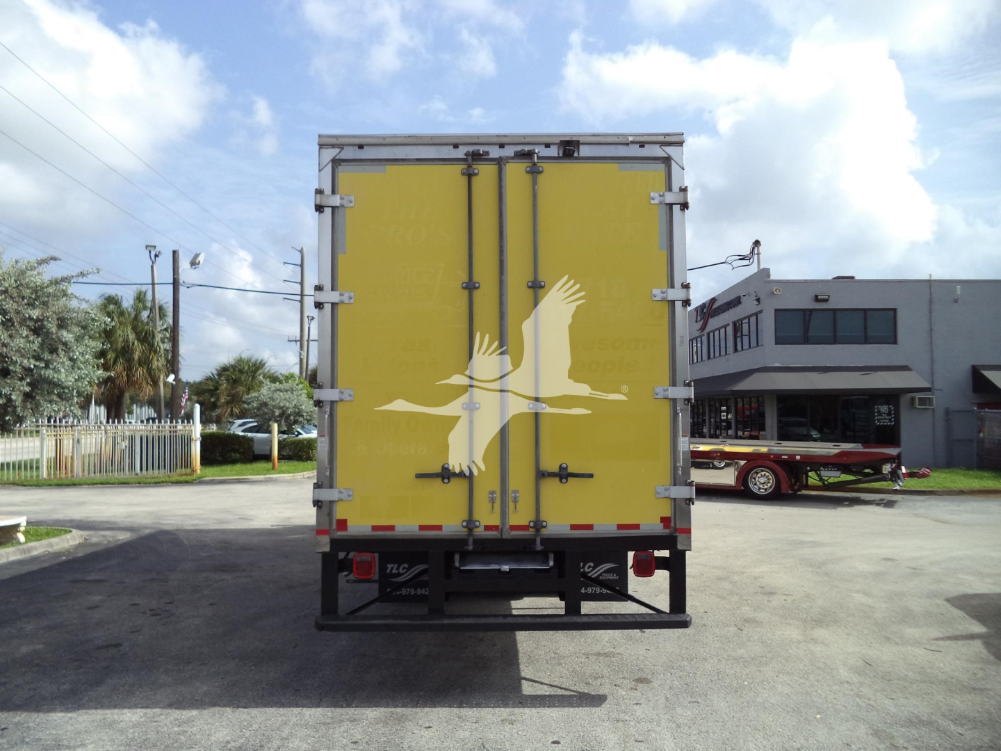 Rear view of 2020 International MV moving van with yellow doors and white bird logo, stock number T94955.