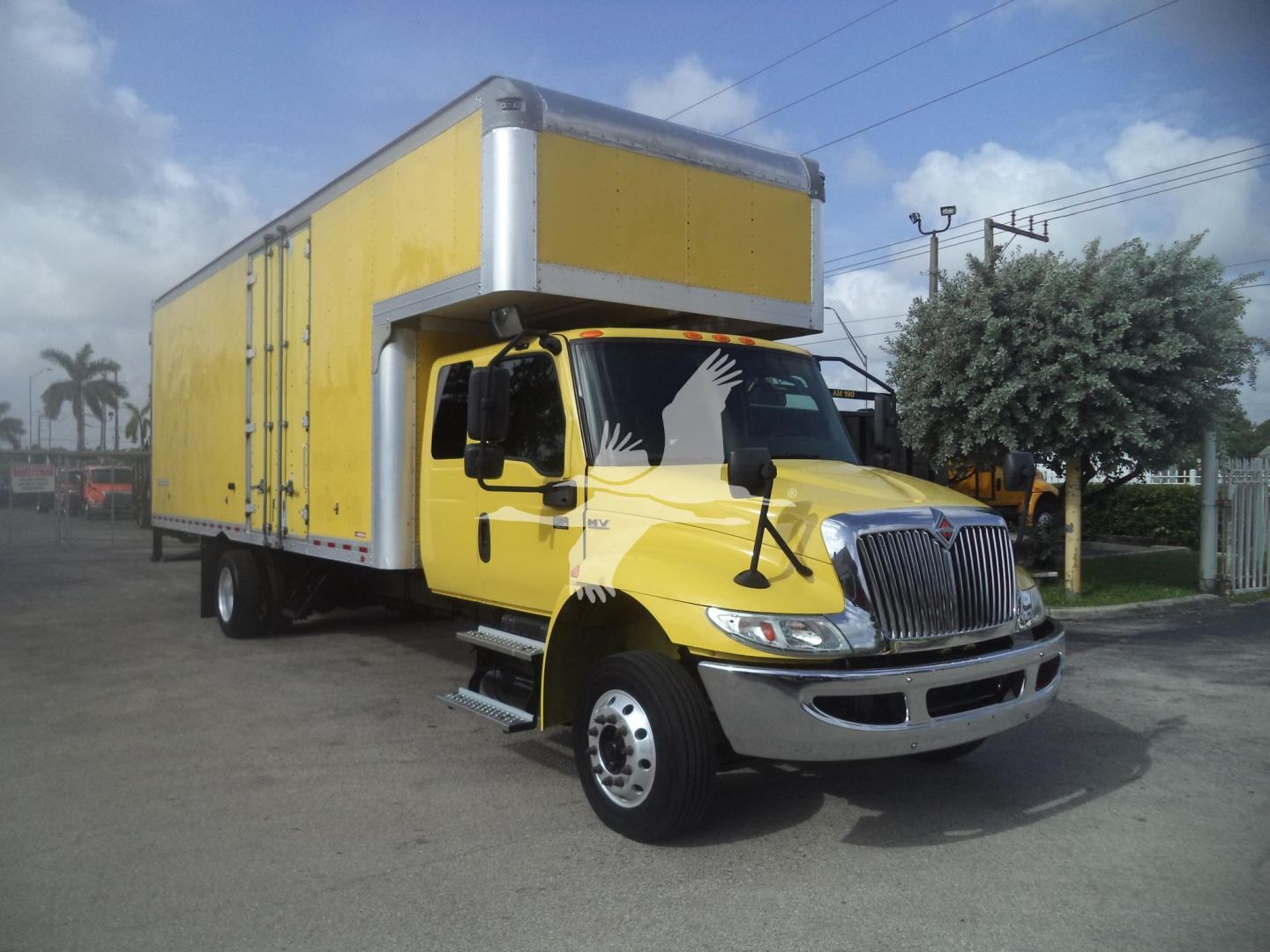 Truck with yellow cab and yellow box body, International MV 2020, side view.