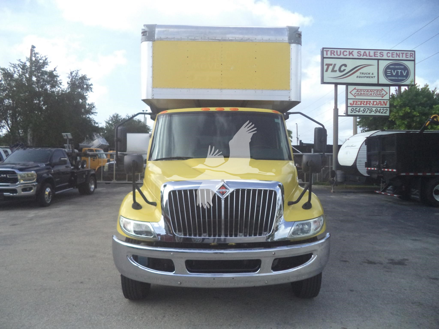 Truck front view of a yellow 2020 International MV with a large box, chrome grille, and logo centered.