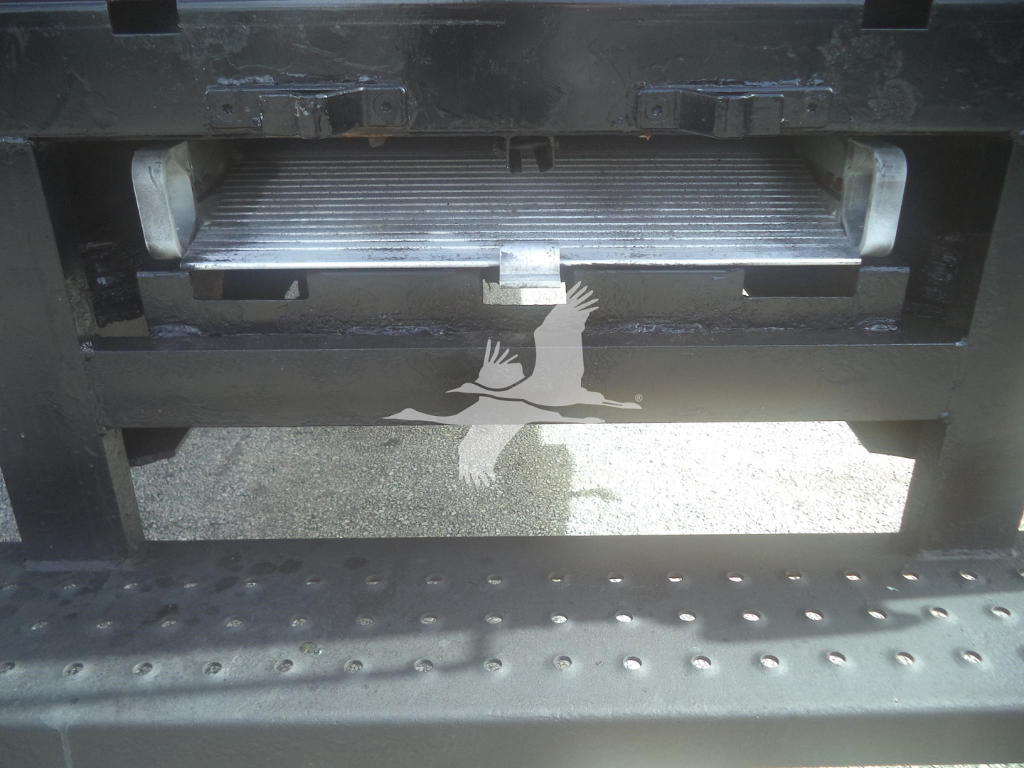 Truck staging area showing a metal intake grill and step area of an International MV truck.