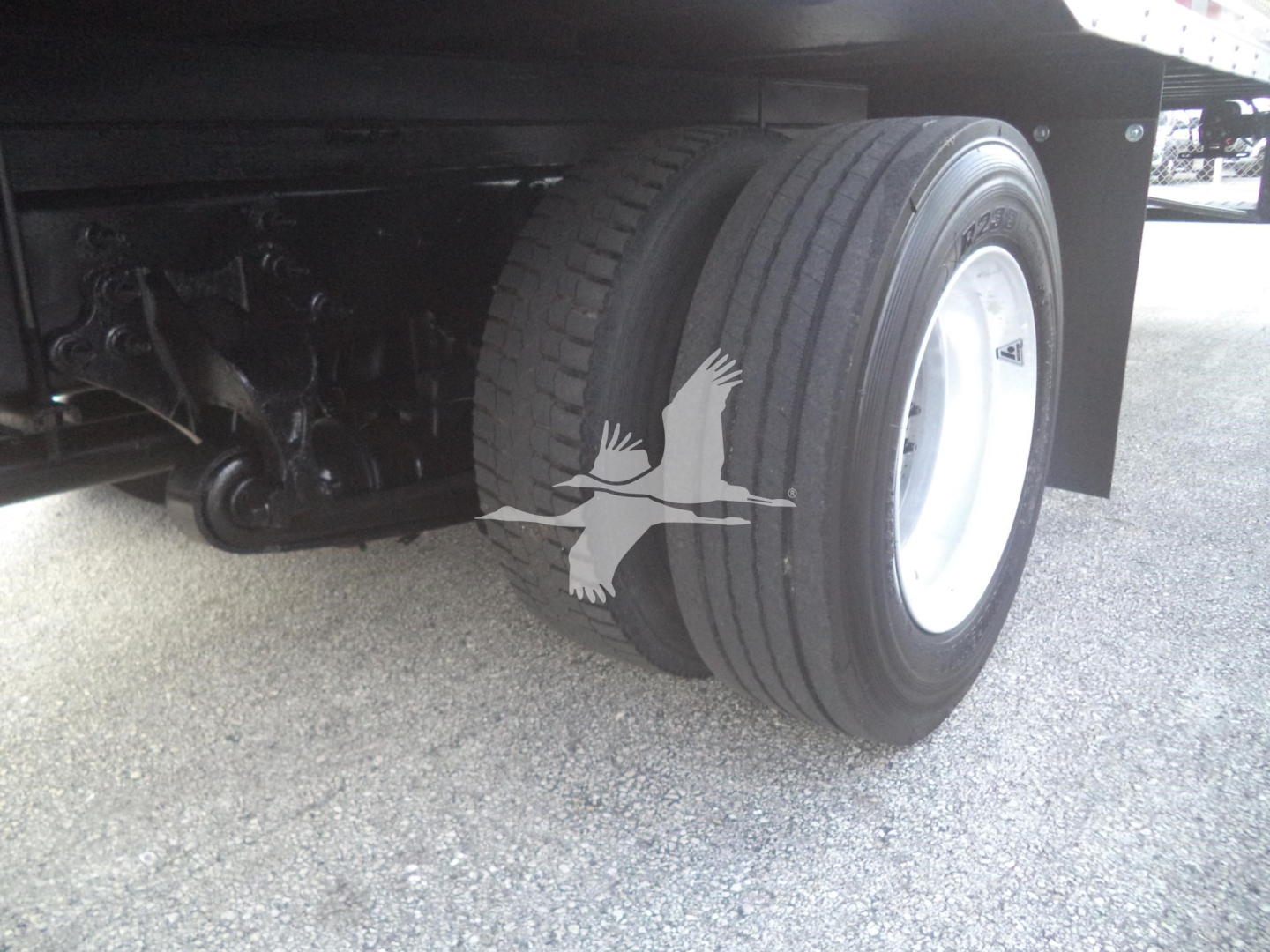 Truck rear dual wheels and chassis showing tire tread and suspension components