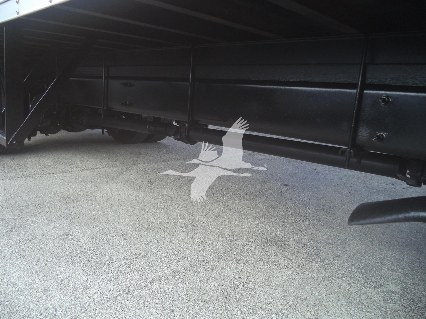 Side view undercarriage of a 2020 International MV moving van showing underframe rails and suspension components.