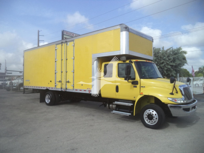 Yellow 2020 International MV moving van with long box cargo area and cab; visible details include VIN and stock in listing context.