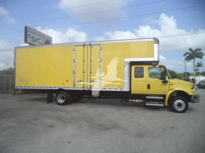 Truck side view: yellow moving van/box truck with extended cargo area and steps, International logo on cab, no visible text other than stock unit features.