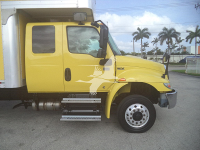 Truck side view showing a yellow 2020 International MV with a box body and chrome step bars.