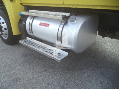 Tank underbody view on a 2020 International MV truck showing horizontal cylindrical fuel or air tank with a platform step and mounting straps.