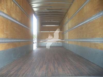 Trailer interior showing wooden floor and metal side rails; faint white image of hands reaching with a circle near the far end.