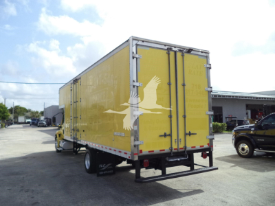 Truck box rear view showing yellow cargo trailer with double doors and black bumper.