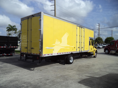 Yellow moving truck with a large box trailer, white crane logo on side, parked in lot.