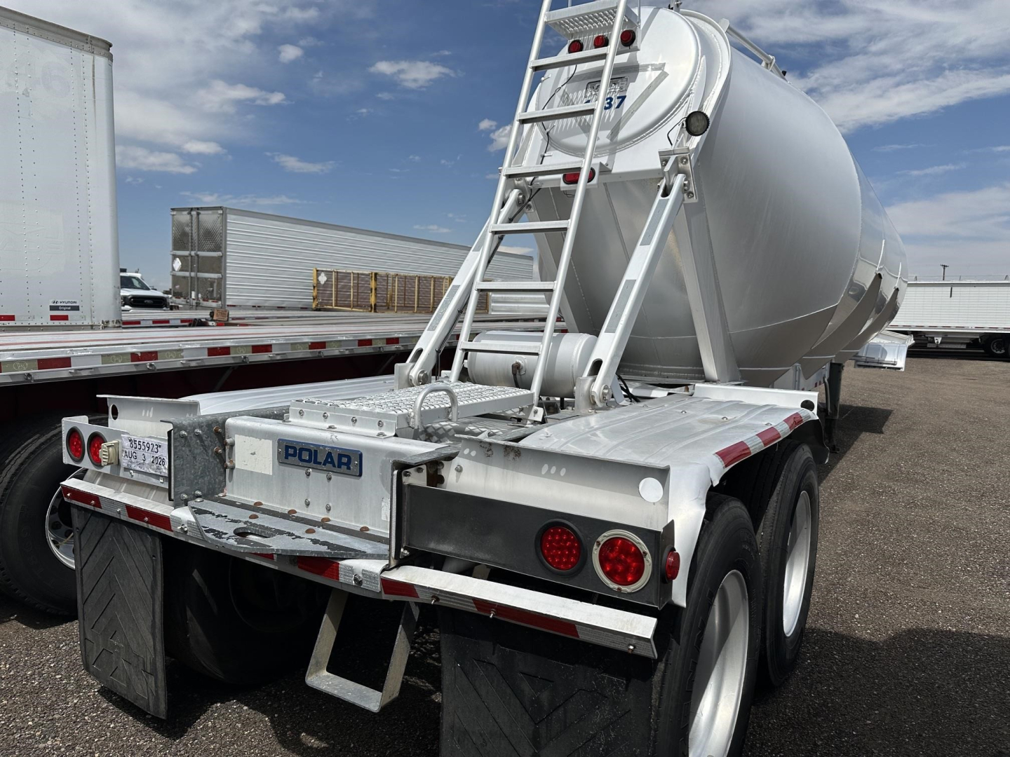 Pneumatic trailer with cylindrical tank, rear view showing Polar branding, ladder, and rear mud flaps.