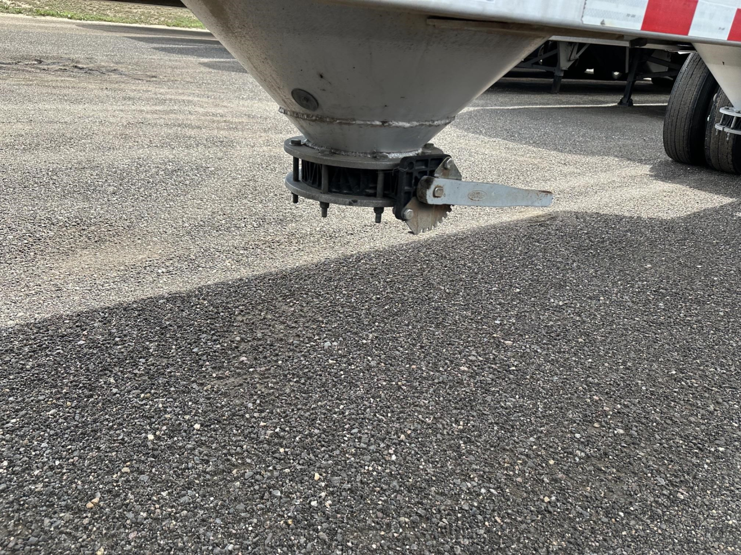 Pneumatic trailer hitch/axle area with grey metallic cone and hitch mechanism visible under the trailer.