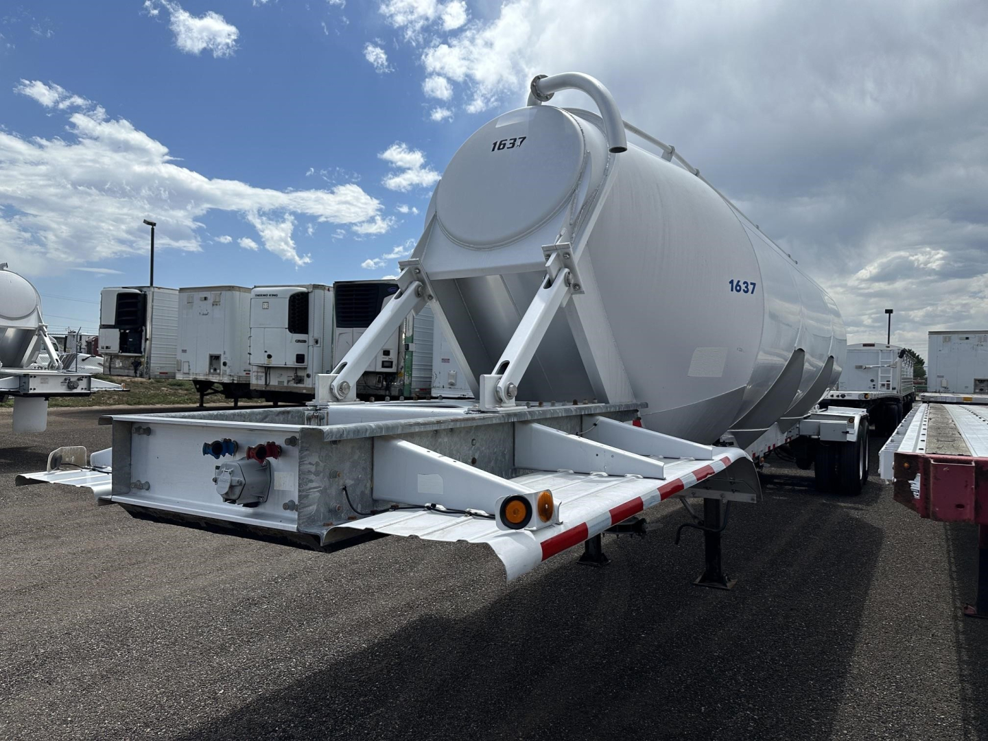 Pneumatic dry bulk trailer by Polar Gravity Drop, 2012 model, mounted on a trailer with cylindrical tank and rear chute, visible VIN/serial numbers 1637 and 1637 on tank, shown in a used equipment lot.