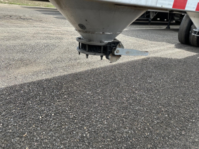 Pneumatic trailer hitch/axle area with grey metallic cone and hitch mechanism visible under the trailer.