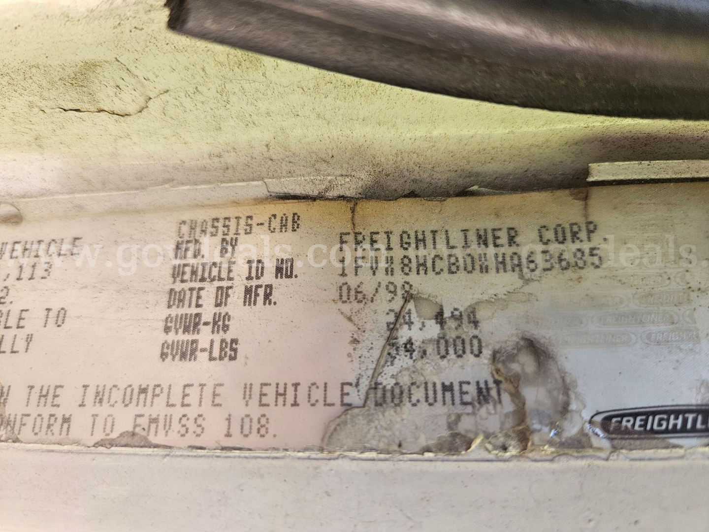 Vehicle data plate on Freightliner cab and chassis showing VIN partial, weight figures, and manufacture date; label includes ‘FREIGHTLINER CORP’ and vehicle ID number.