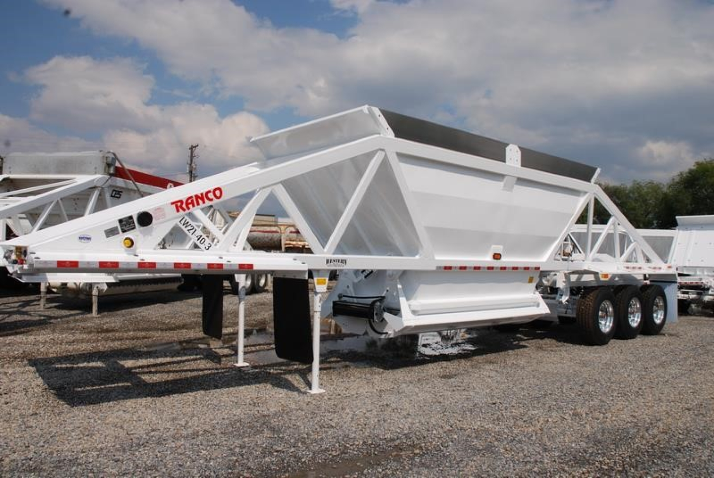 Ranco light weight bottom dump trailer with white frame and tri-axle configuration, side view showing dump hopper and ramp.