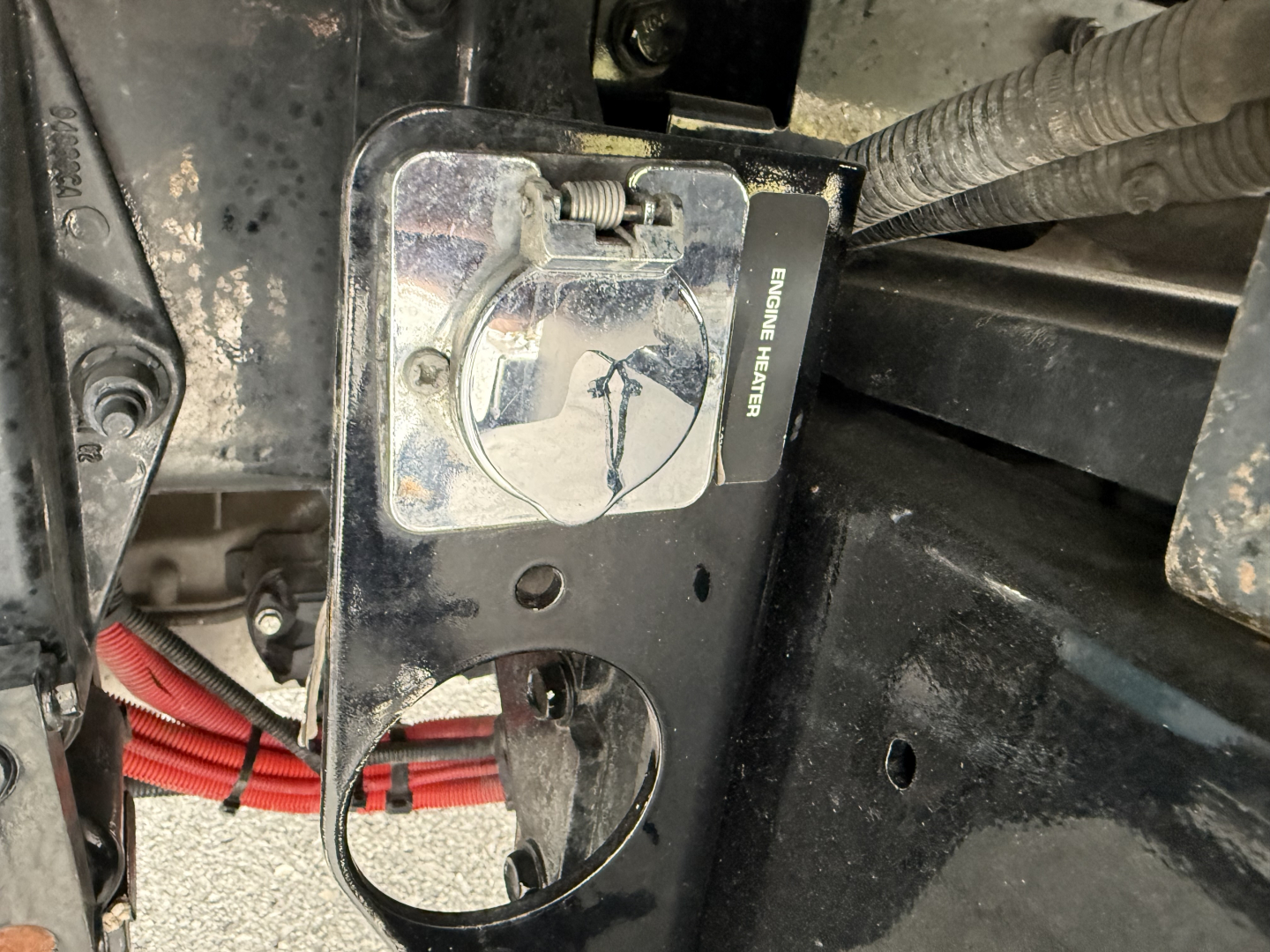 Kenworth T380 engine bay area showing service panel and wiring with label reading 'SERVICE HEATER' and exposed metal brackets.