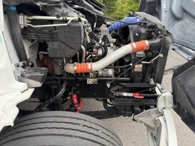 Kenworth T380 engine bay showing coolant hoses, radiator, and engine block with visible components and wiring.